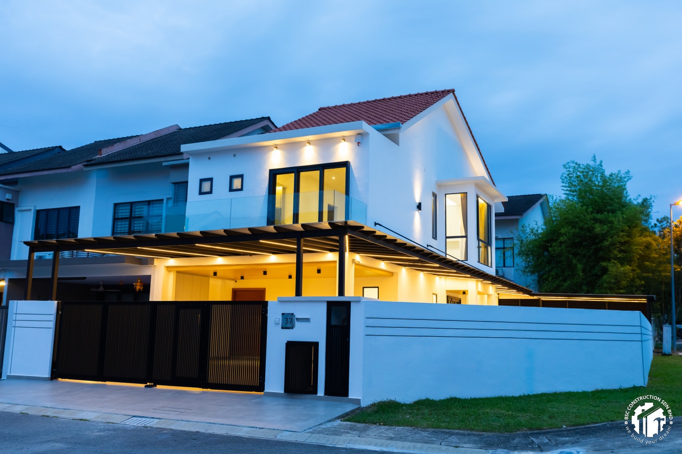 BSC Construction — corner lot house renovation with exterior extension, evening view