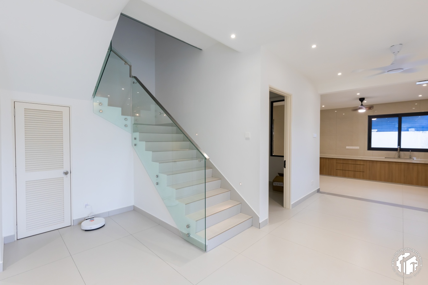 Modern glass staircase with open-concept kitchen view